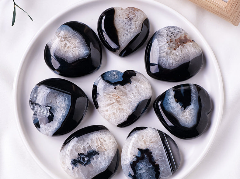 Collection of Black Agate Heart stones with unique patterns arranged on a white plate