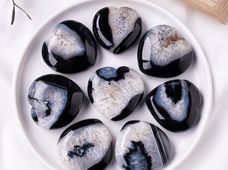Collection of Black Agate Heart stones with unique patterns arranged on a white plate