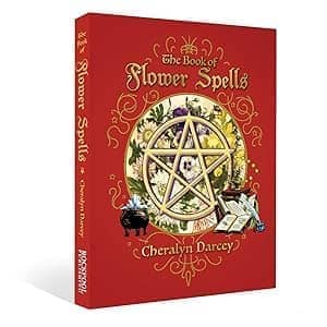 The Book of Flower Spells by Cheralyn Darcey featuring a pentagram and floral designs on a vibrant red cover