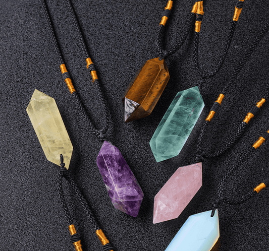 Natural Rose Quartz Pendant among other crystal pendants on black background