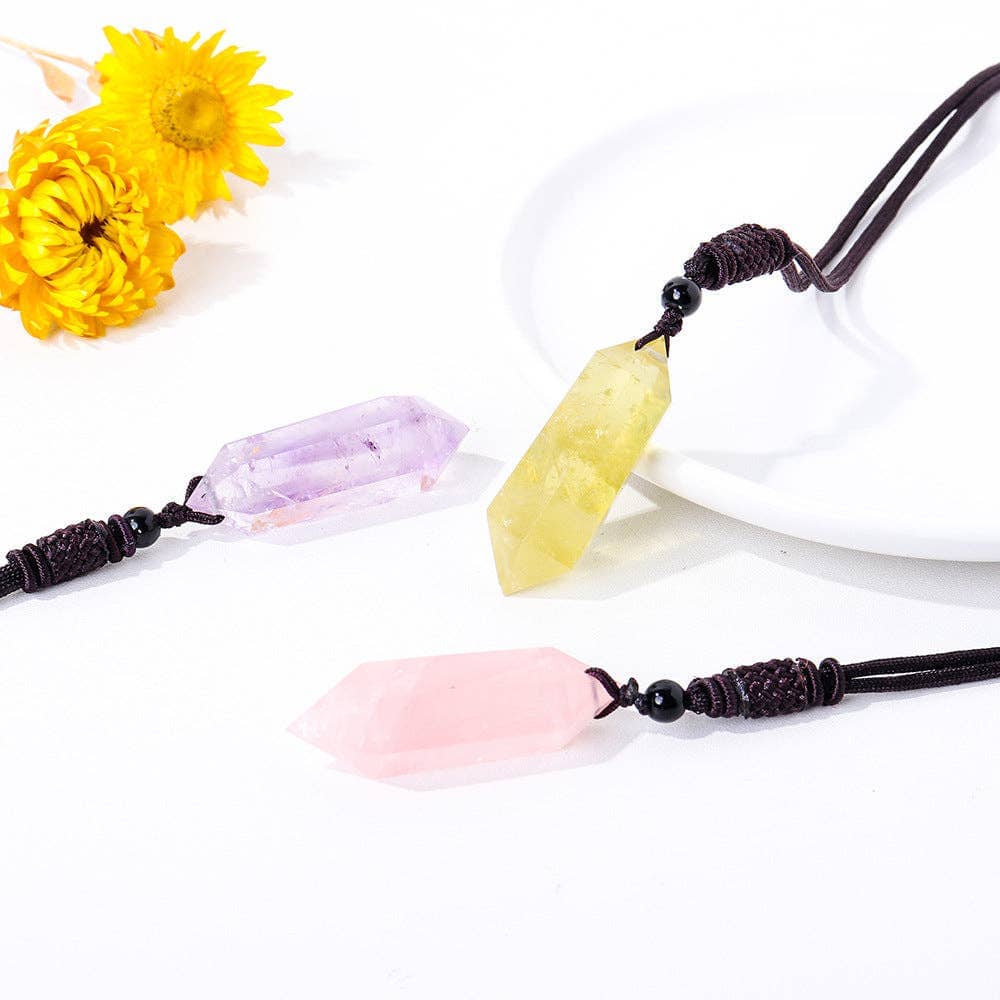 Natural Rose Quartz Pendant among Amethyst and Citrine on a white plate with yellow flowers