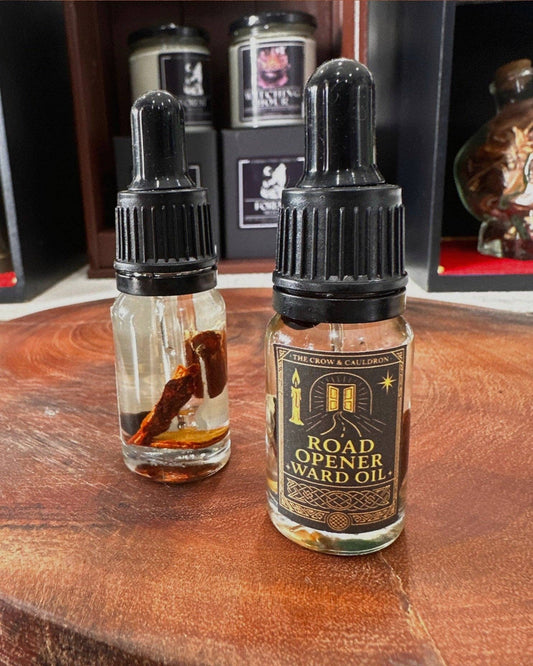 The Crow and Cauldron - 10ml Curio Oil - Road Opener in a glass bottle on a wooden surface