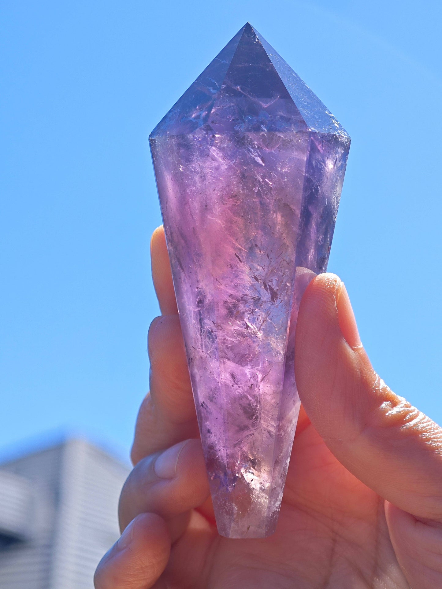 Natural Brazilian Amethyst Wand held in hand with vibrant purple hues and crystal clarity
