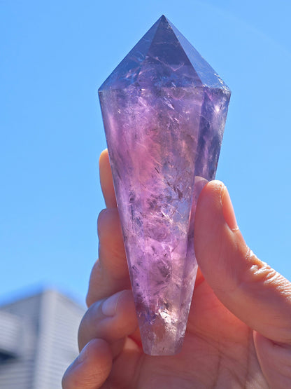 Natural Brazilian Amethyst Wand held in hand with vibrant purple hues and crystal clarity