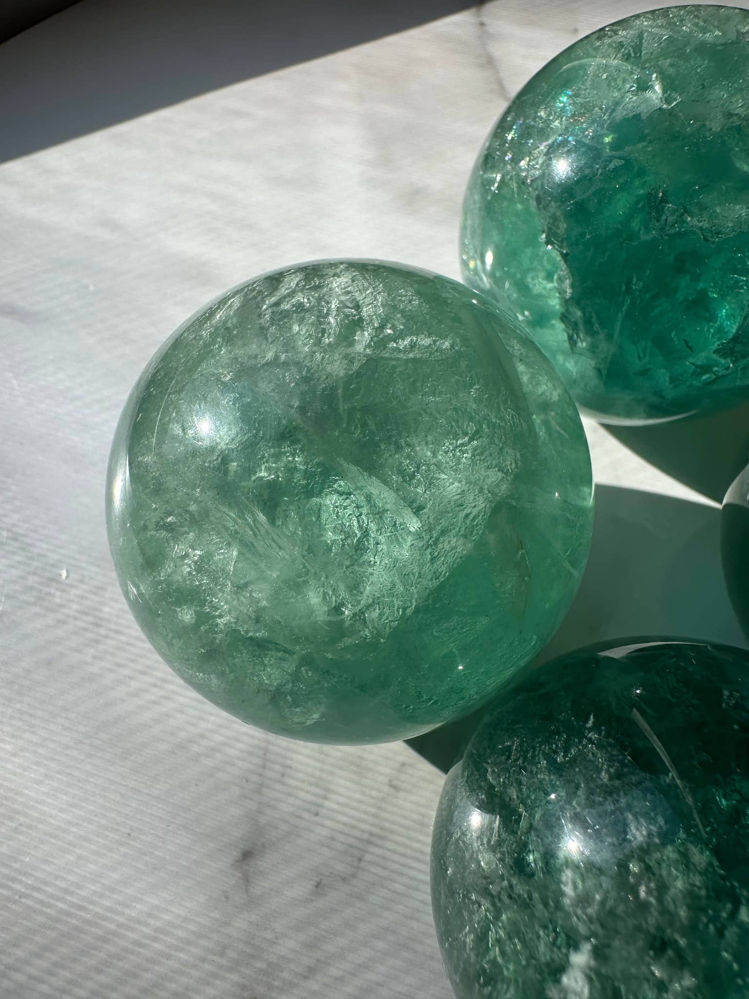 Natural Green Fluorite Sphere showcasing vibrant green hues and translucent surface for decor or healing