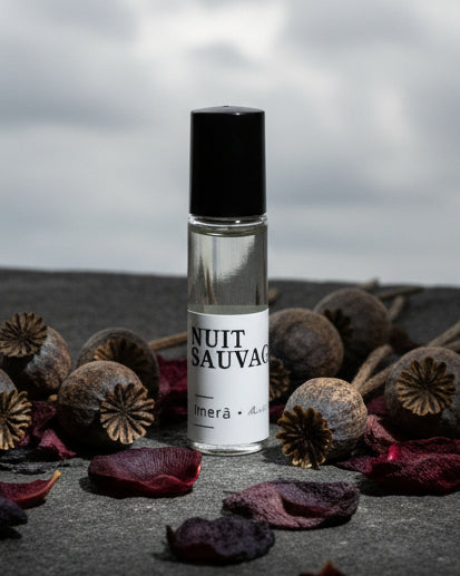 Small glass bottle with a black cap on a white background