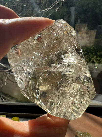Hand holding a Brazilian Golden Healer Quartz Freeform with sparkling clarity and unique natural shape