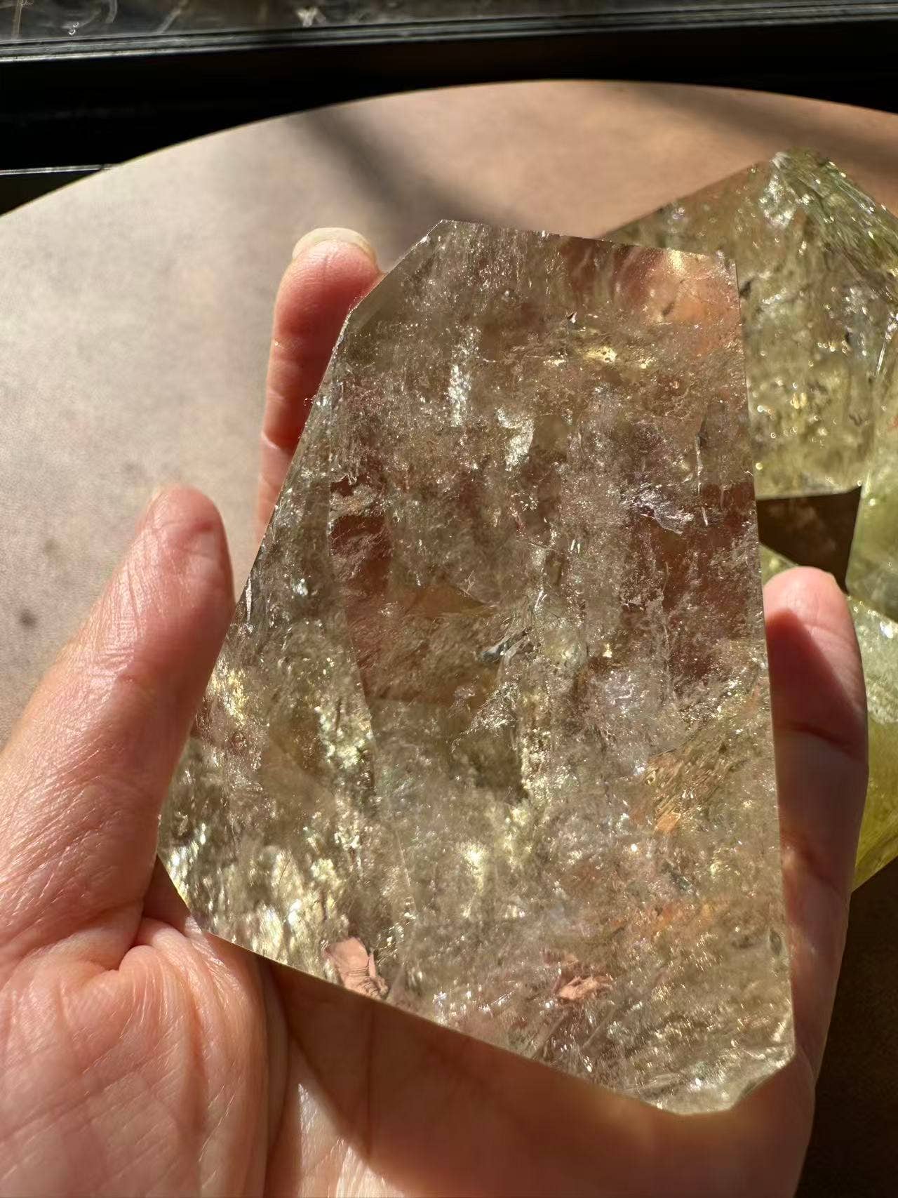 Hand holding Brazilian Golden Healer Quartz Freeform showing its unique shimmering texture