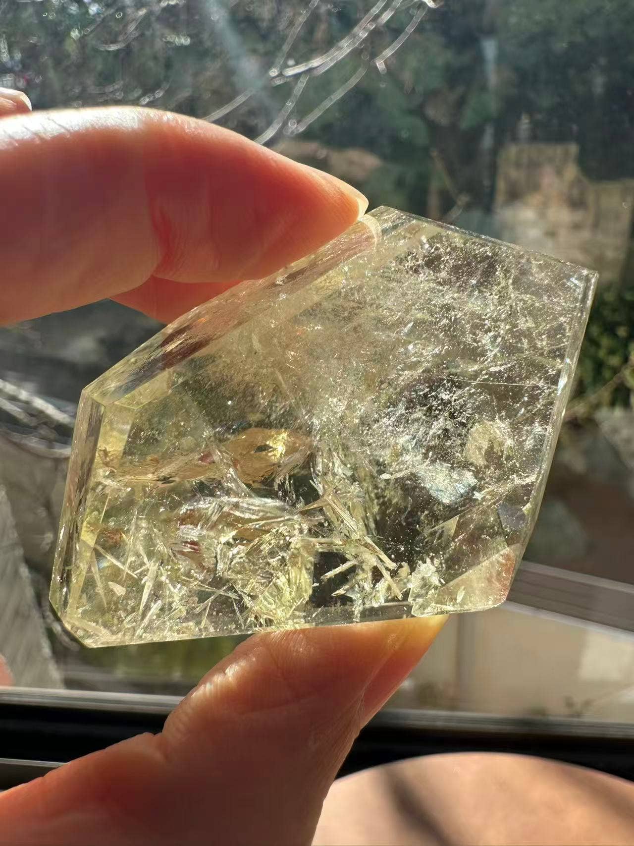 Hand holding a Brazilian Golden Healer Quartz Freeform crystal with natural inclusions and a beautiful shine