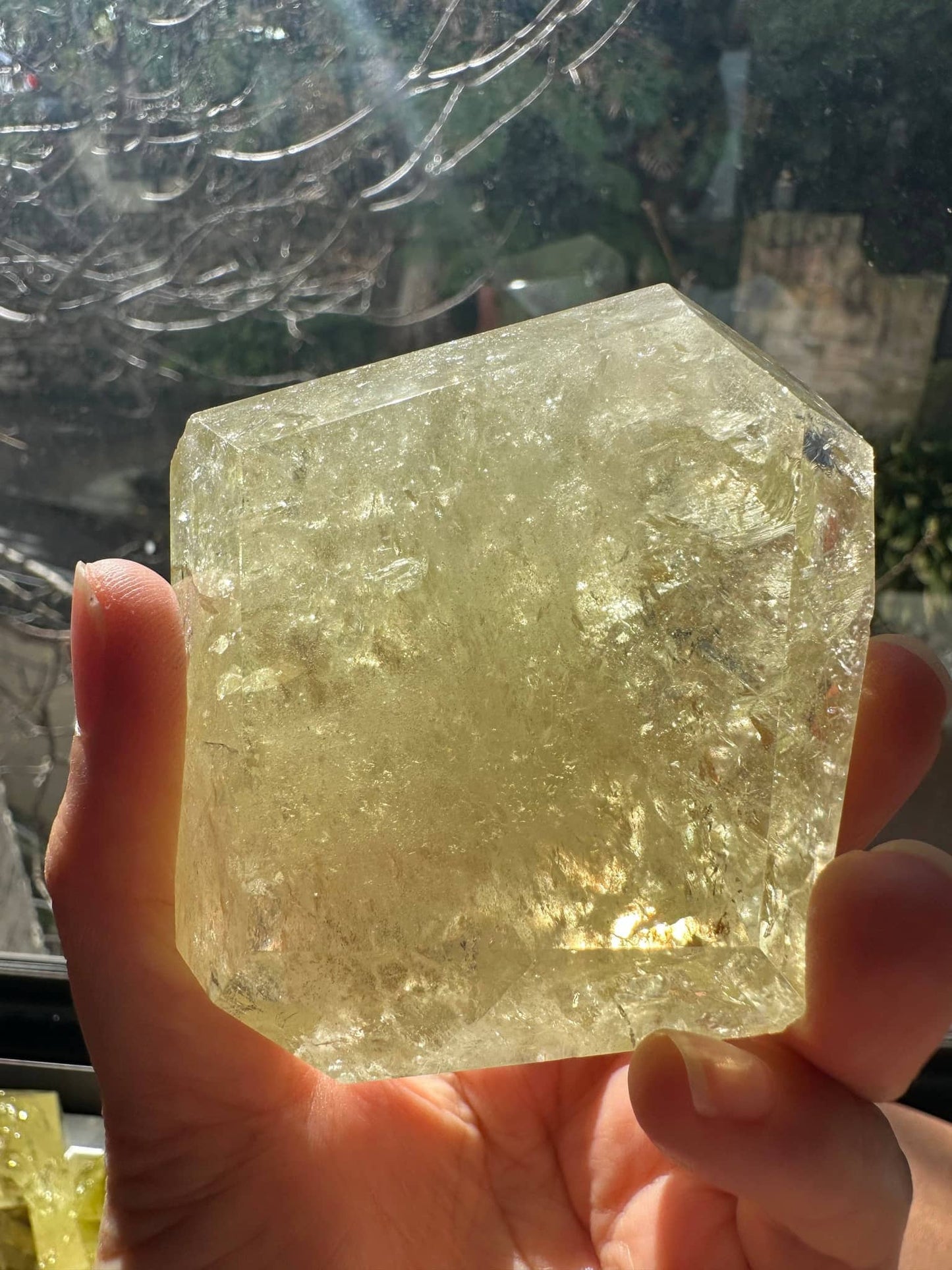 Hand holding Brazilian Golden Healer Quartz Freeform crystal with a natural yellow hue