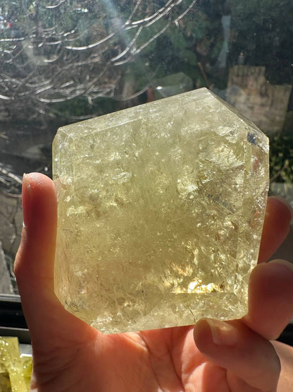 Hand holding Brazilian Golden Healer Quartz Freeform crystal with a natural yellow hue