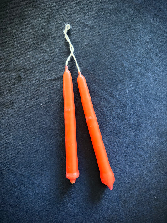 Two Small Spell Candle Orange sticks on a dark background, ideal for rituals and enhancing intentions